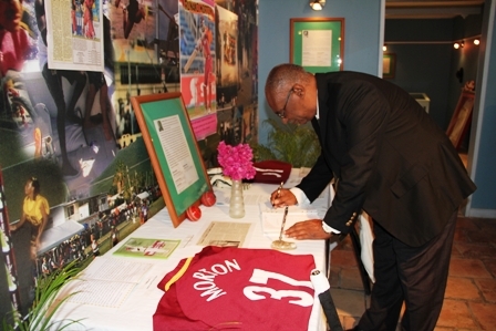 Premier of Nevis Hon. Joseph Parry signs the condolence book in memory of Nevis’ cricket icon Runako Morton at the Sports Museum in Charlestown. His tribute reads: “Joseph W. Parry Premier – May the love of God embrace him”
